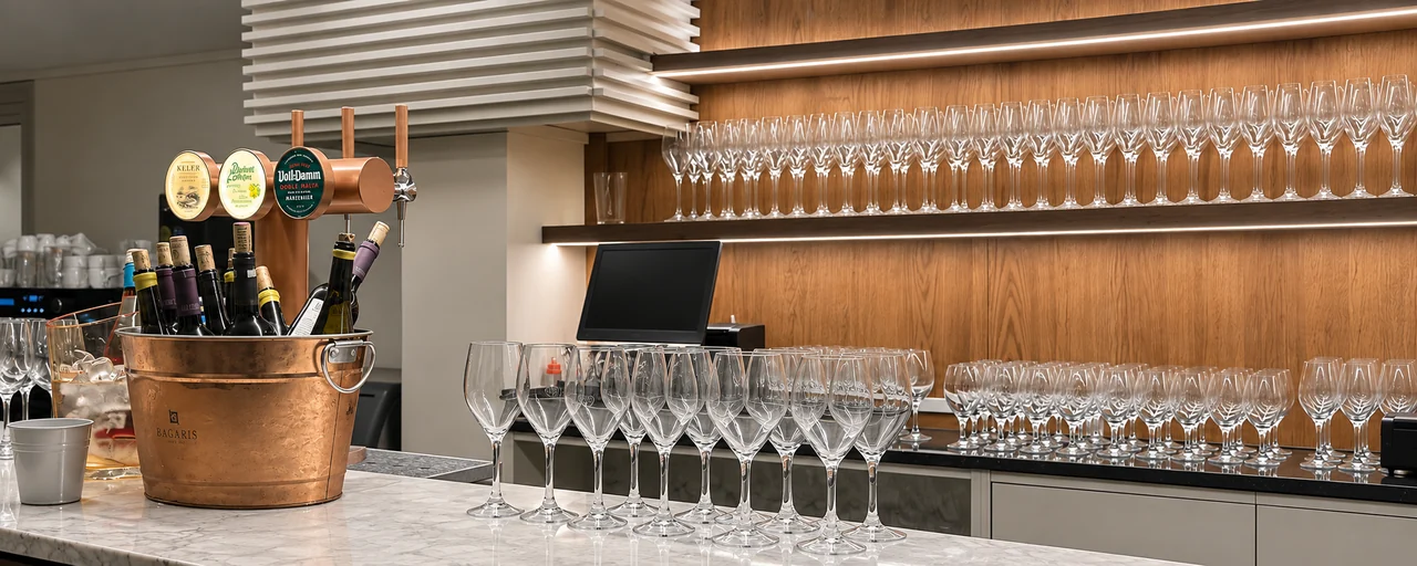 Estantería de madera con copas de vino alineadas sobre barra de mármol